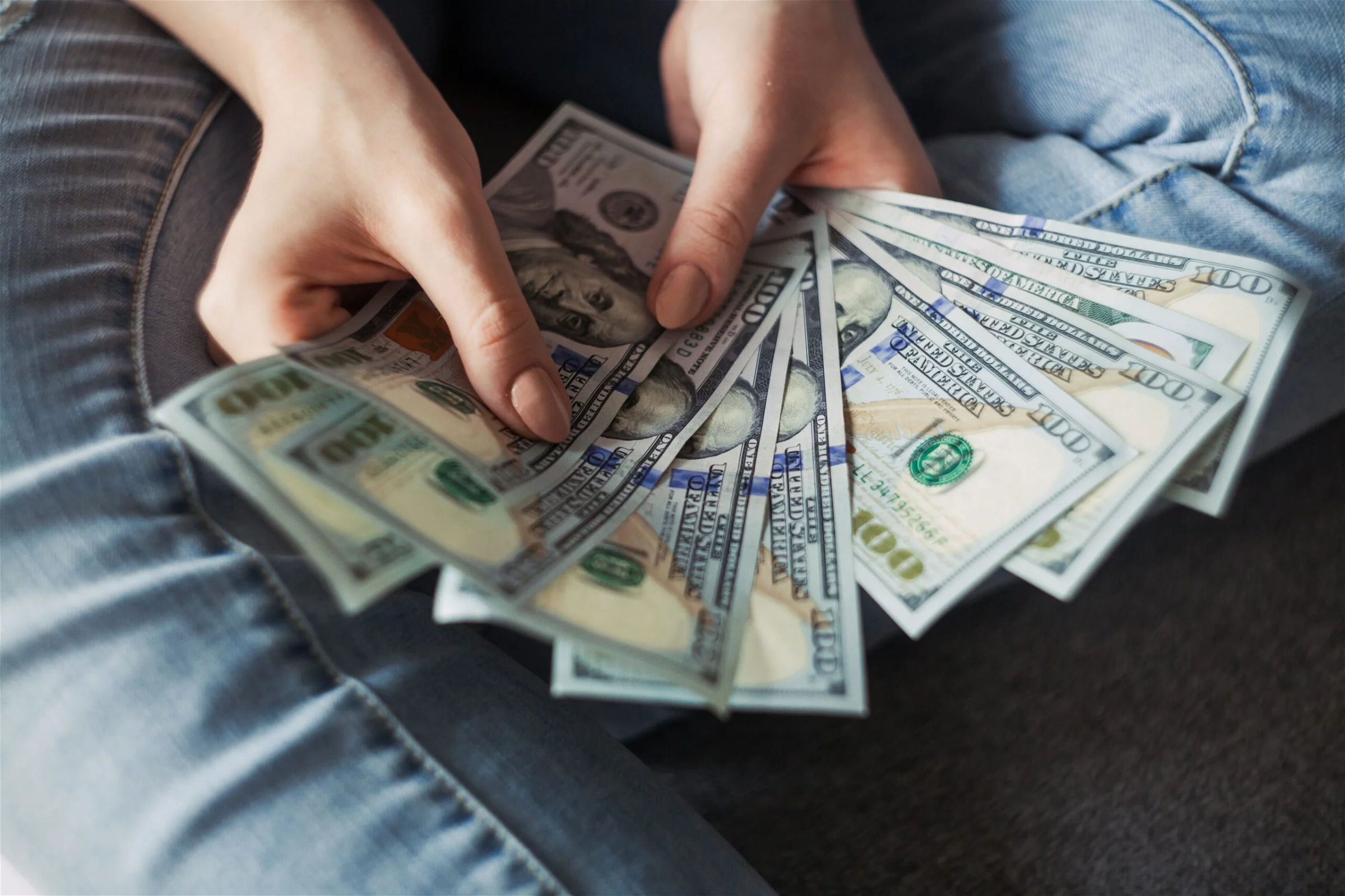 Image of a woman holding money in her hands - Destination Certification