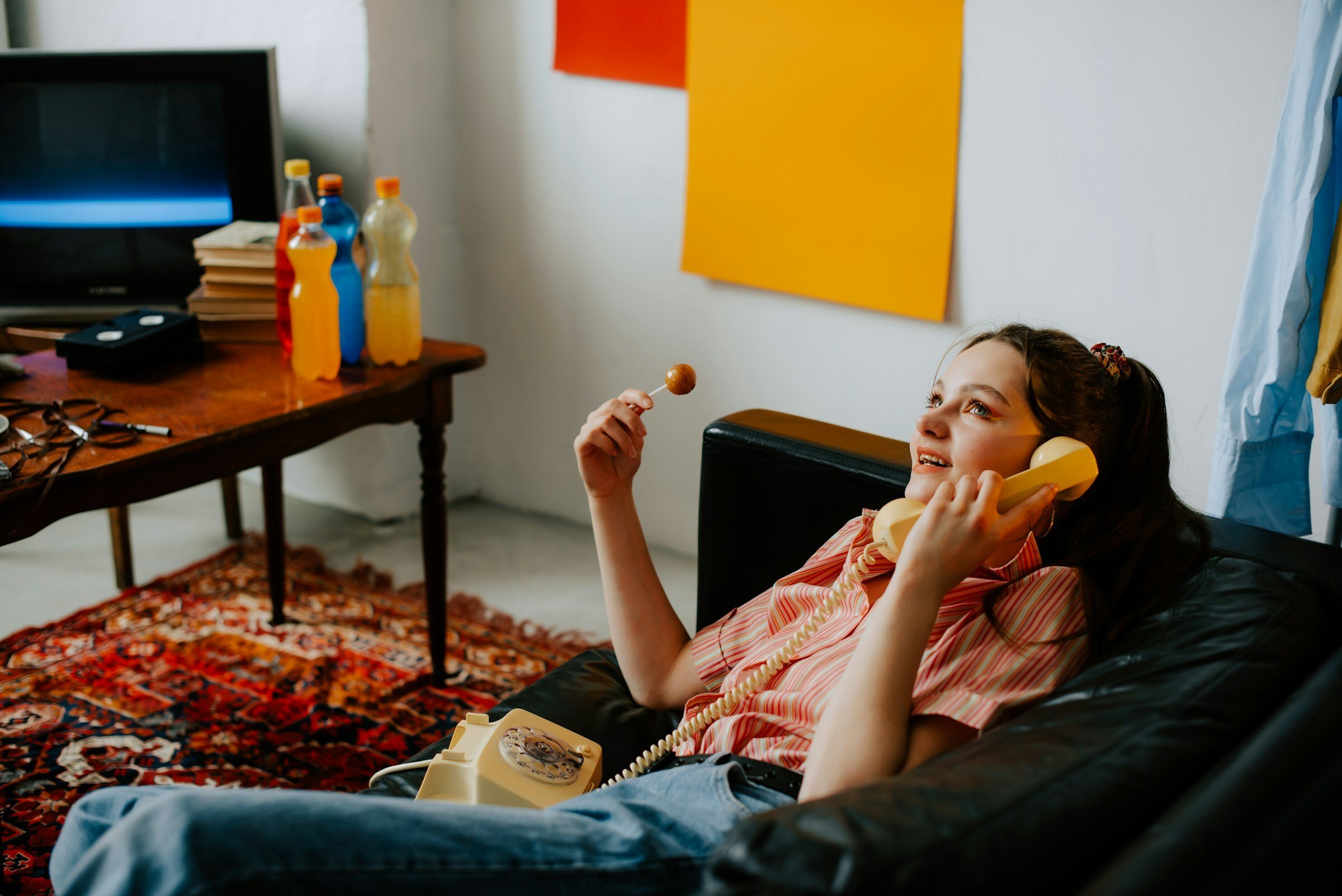 Image of a girl that is laying on the sofa with yellow phone in her hand - Destination Certification