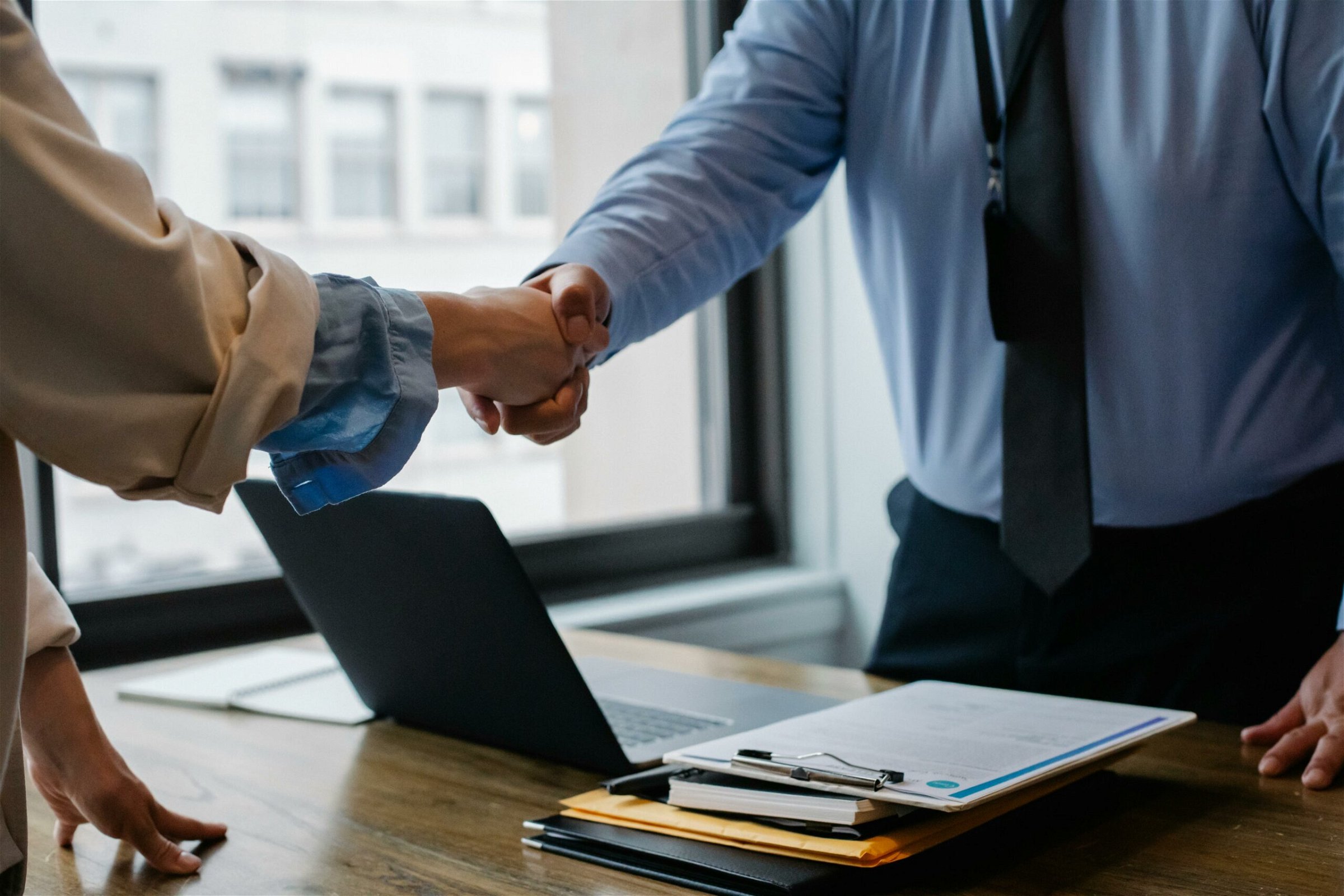 Image of a man and woman shaking hands over a desk table - Destination Certification