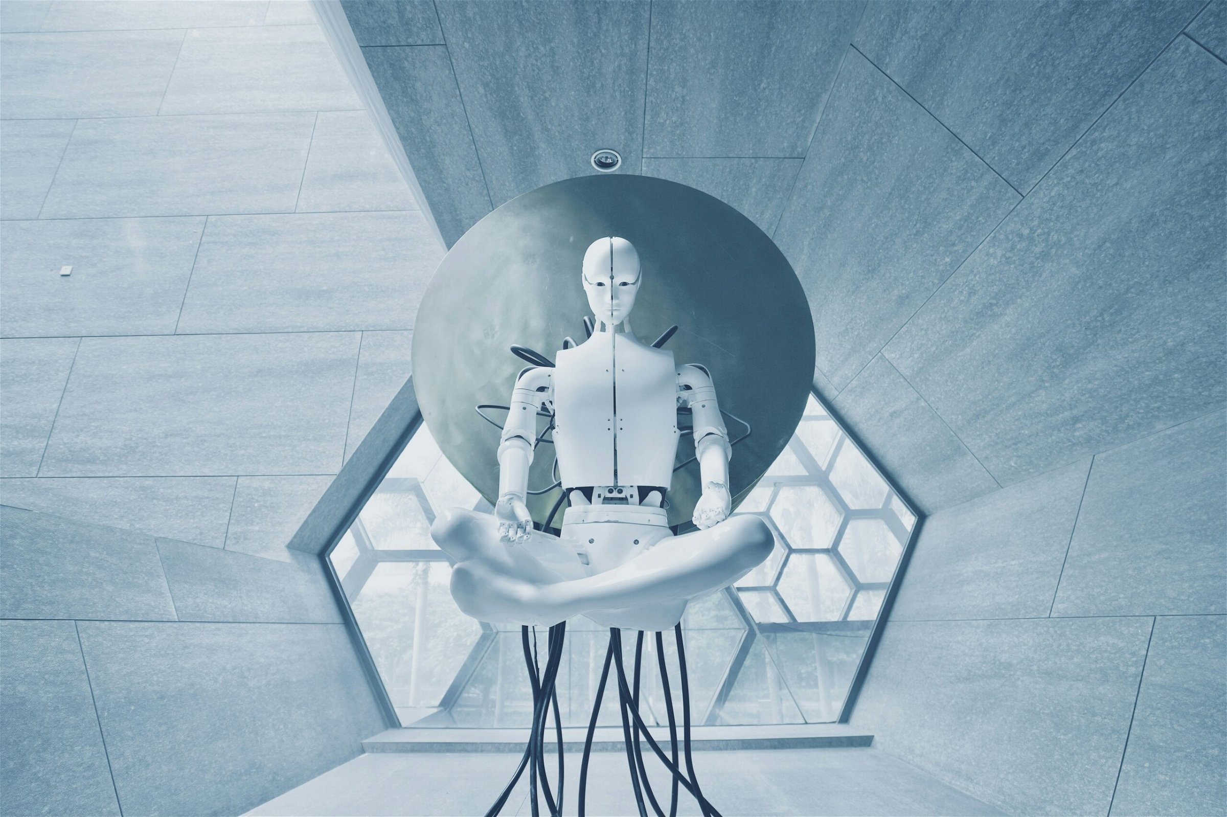 Image of a white robot sitting on a chair in a weird futuristic room - Destination Certification