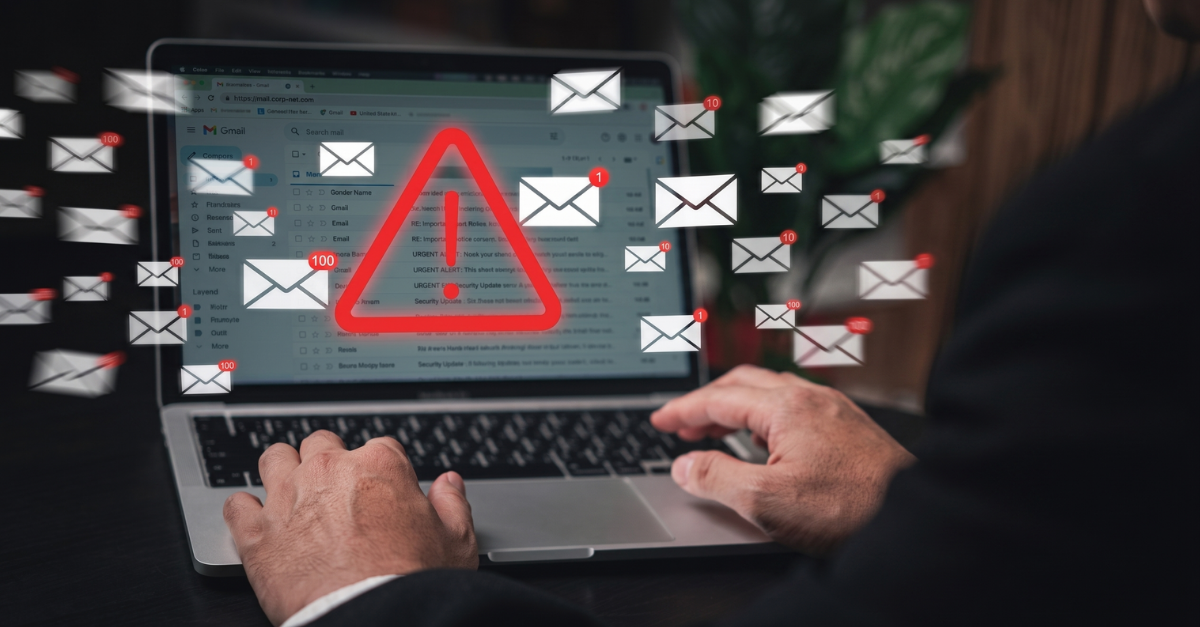 Laptop showing Gmail inbox with red warning triangle and dozens of email icons floating around it, illustrating email breach - Destination Certification